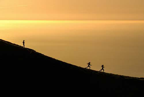 sunrise three persons running downhill during golden hour sunset
