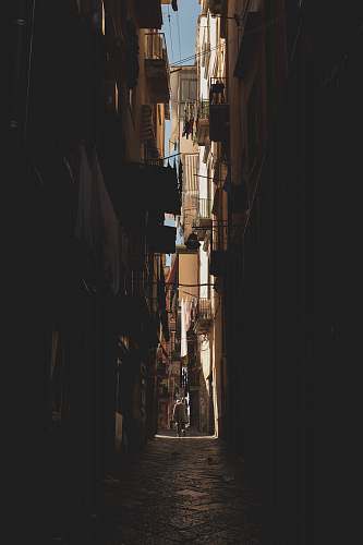 alley person walking in middle of buildings alleyway