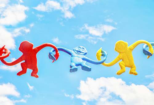 fun three assorted-color monkey plastic toys holding each other during daytime lake buena vista