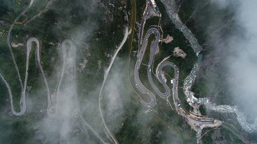 drone bird's eye view photography of curved pave road road