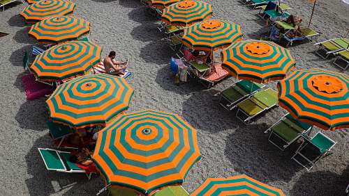 person orange and green beach umbrella view human