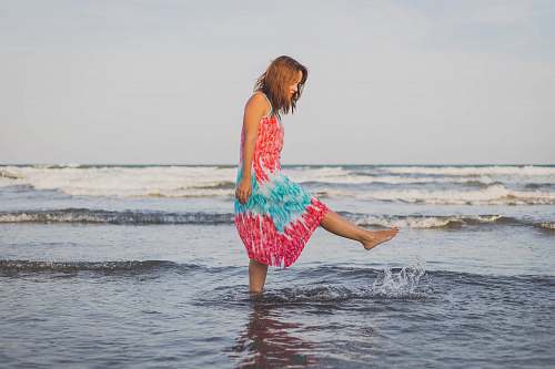 beach woman playing with water on shore during daytime coast
