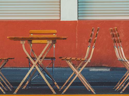 germany brown wooden table and chair near red wall chair