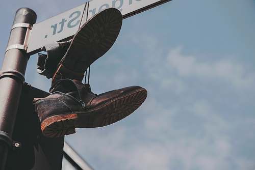 germany pair of black boots hanged on street post boot