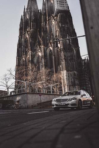 cologne gray car on asphalt road near castle during daytime church