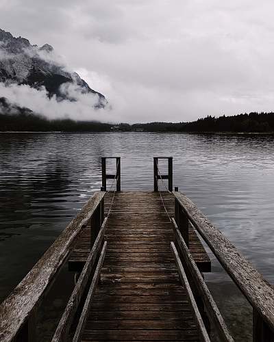 pier brown wooden dock near mountain at cloudy sky dock