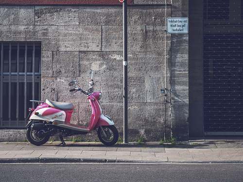 vehicle parked pink motor scooter motorcycle