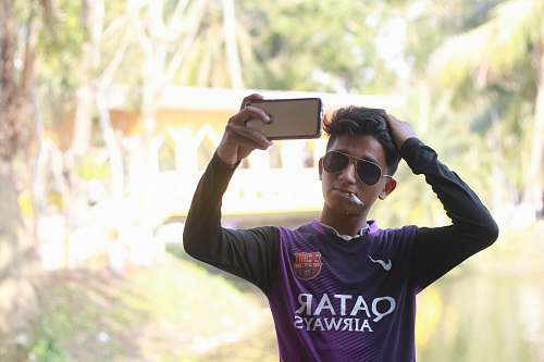 accessory man wearing purple Nike Qatar Airways jersey shirt sunglasses