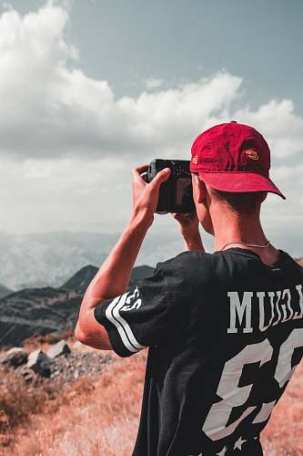 clothing man taking photo of mountain hat