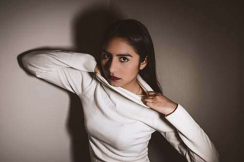 clothing woman in white sweater grabbing out own shrit sleeve