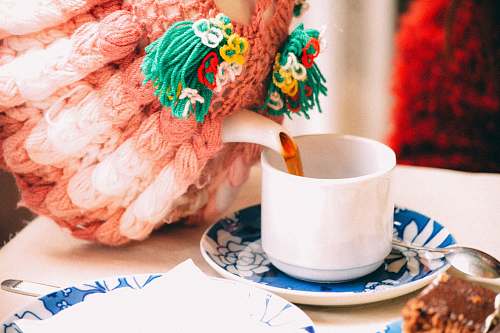 saucer selective focus photography of person pouring teacup tea