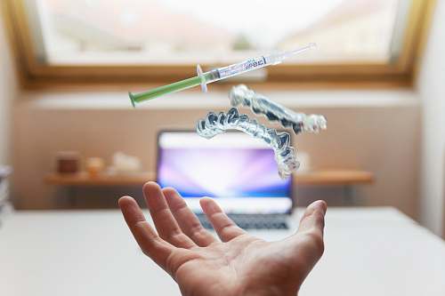dentist open palm with syringe floating above hand