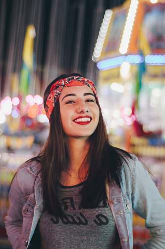 smile selective focus photography of smiling woman wearing red and black bandana human