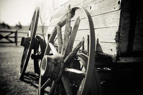 wheels grayscale photo of wagon wheel person