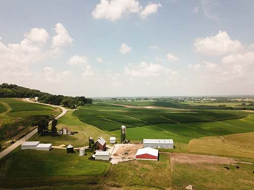 nature bird eye view photography of white and brown house surrounded by green grass field countryside