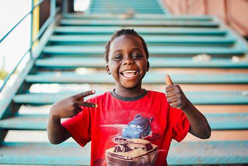 people boy standing near stairs doing peace sign at daytime person