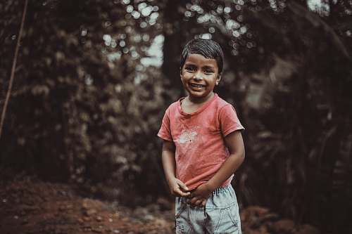 people boy wearing red shirt smilinig person