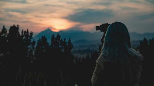 person landscape photo of a camera woman at sunset photo