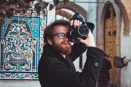 person man standing and using DSLR cameta camera