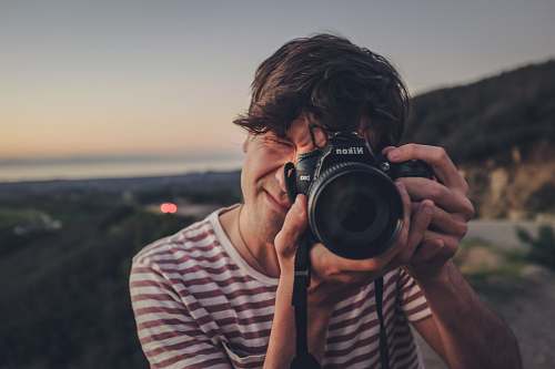 person man taking photo of black bridge camera electronics