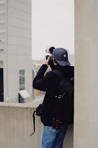 person man taking photo of concrete building photographer