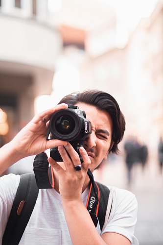person man taking photo using Canon DSLR camera camera