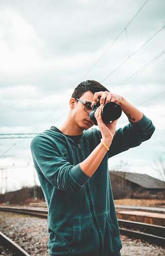 person man wearing black jacket taking photo photo