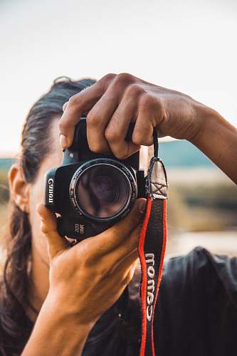 person person holding black Canon camera close-up photography camera
