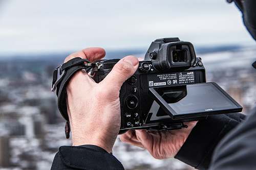 person person holding black DSLR camera camera