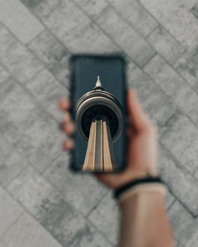 person person holding CN Tower print phone case wristwatch