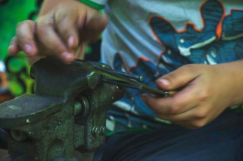 person person holding gray bench vise gun