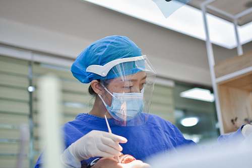 person person in blue scrub suit wearing white mask doctor