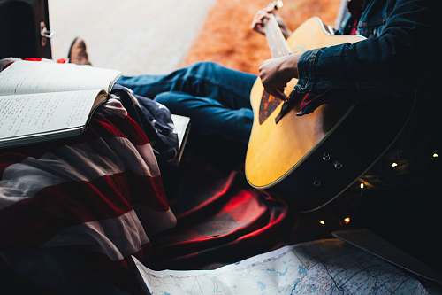 person person playing guitar while looking at lyrics music
