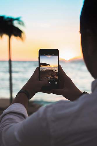 person person taking photo of beach people