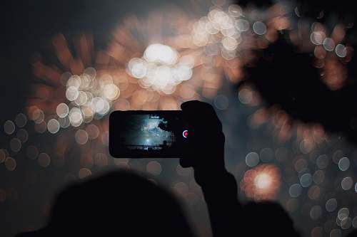 person silhouette of person taking photo during nighttime photo