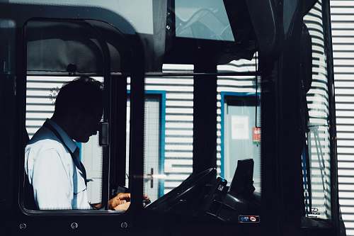 person silhouette photography of man driving bus krakow