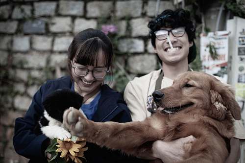 person two smiling woman and man while carrying dog accessories