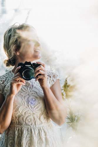 person woman holding DSLR camera camera