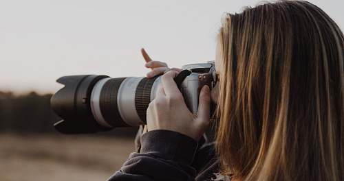 camera woman holding DSLR camera taking photo photography