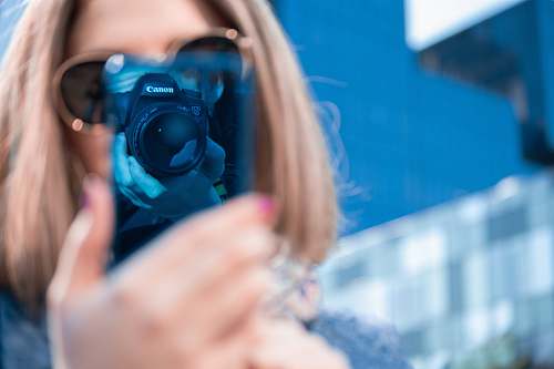person woman taking picture of her smartphone camera