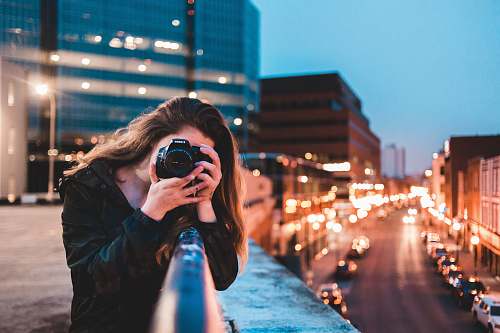 person woman using black camera outdoors photo