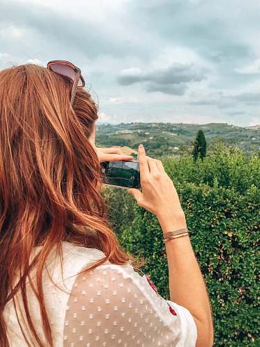 person woman using black smartphone sunglasses