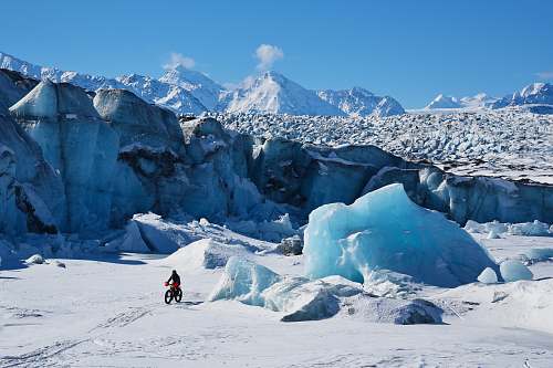 mountain man using bicycle on snow glacier