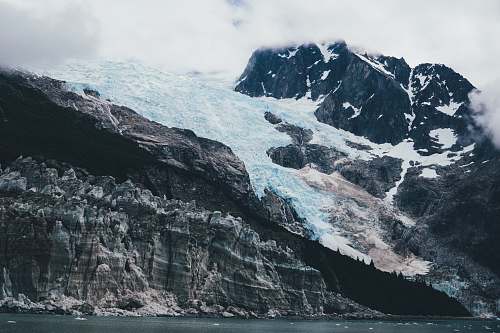 nature snow covered mountain under white clouds glacier