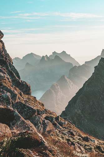 nature closeup photo of rocky mountain under blue and white sky norway
