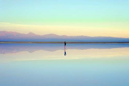 people person standing near body of water during daytime reflection