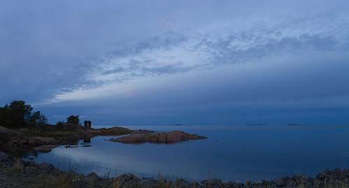 land landscape photography of blue sea under cloudy sky nature
