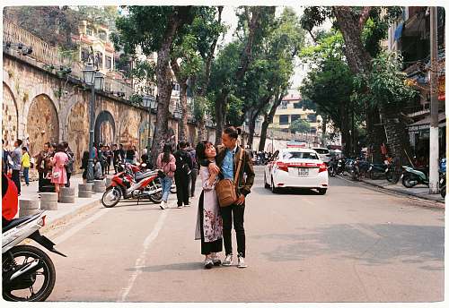 human man and woman standing on the street while hugging each other person