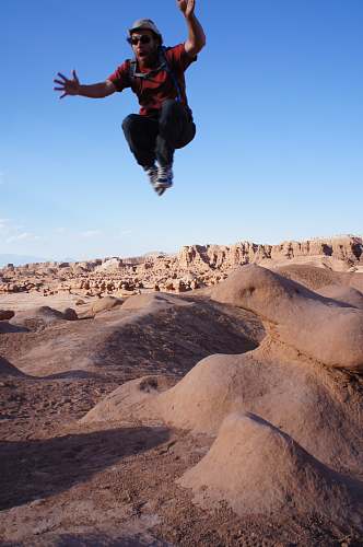 human man jumped on desert during daytime person