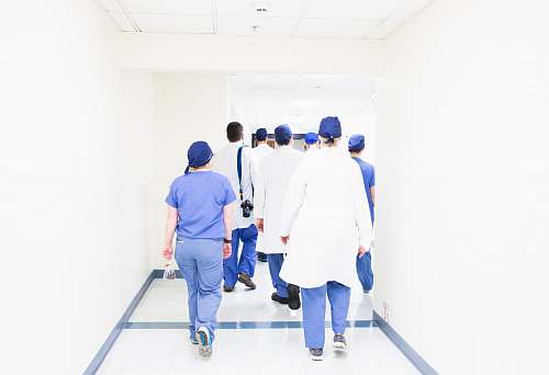 human group of doctors walking on hospital hallway people